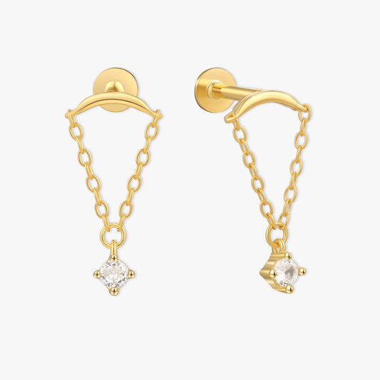 Gold earrings with chain and clear gemstones on a white background