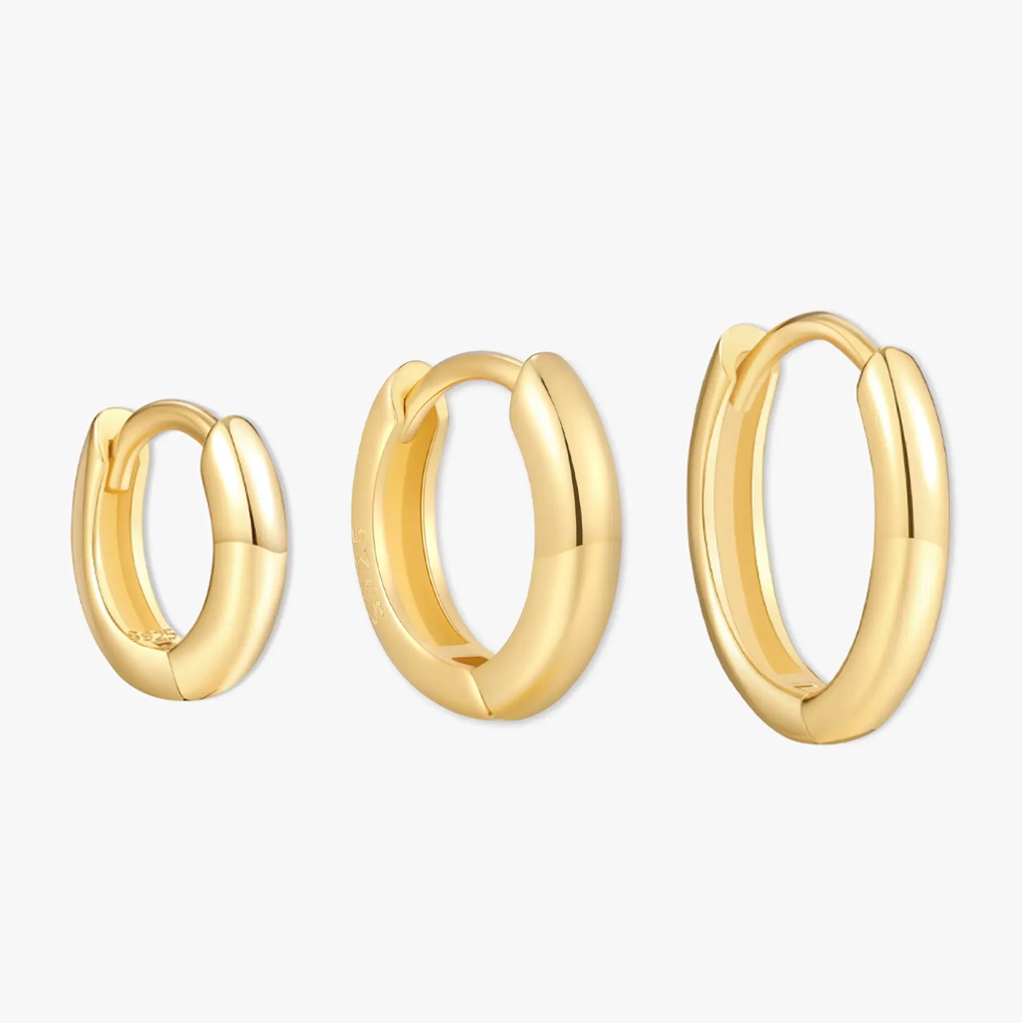 Three gold hoop earrings on a white background