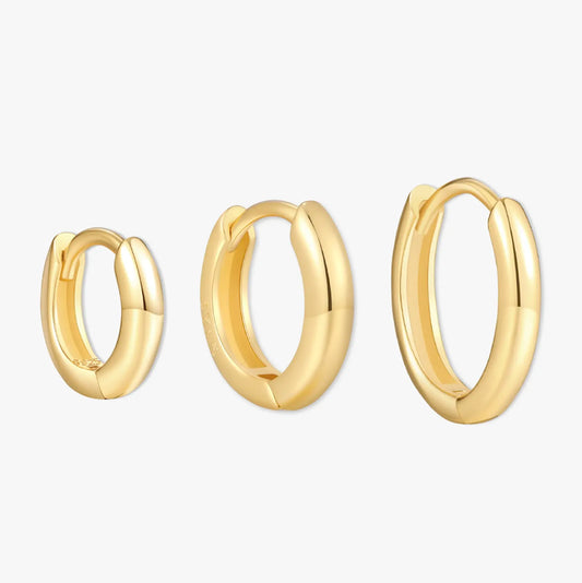 Three gold hoop earrings on a white background