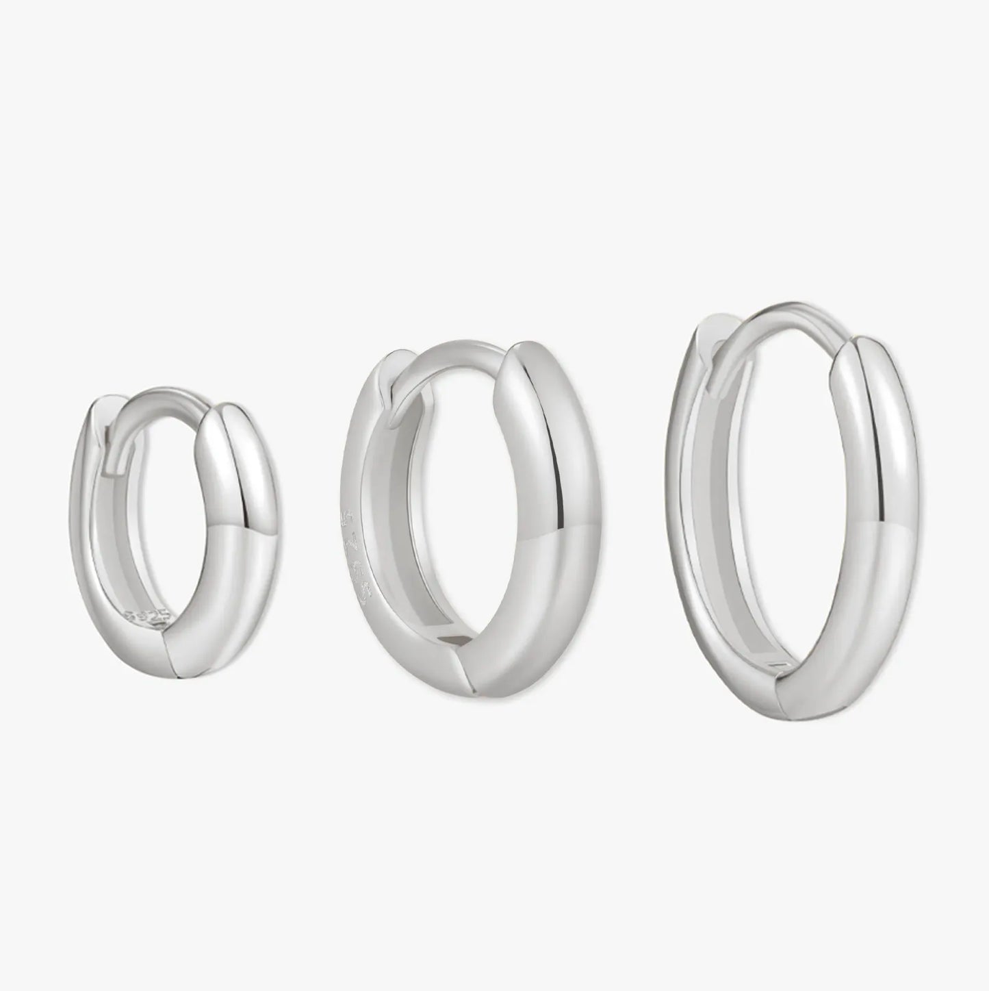 Set of three silver hoop earrings on a white background
