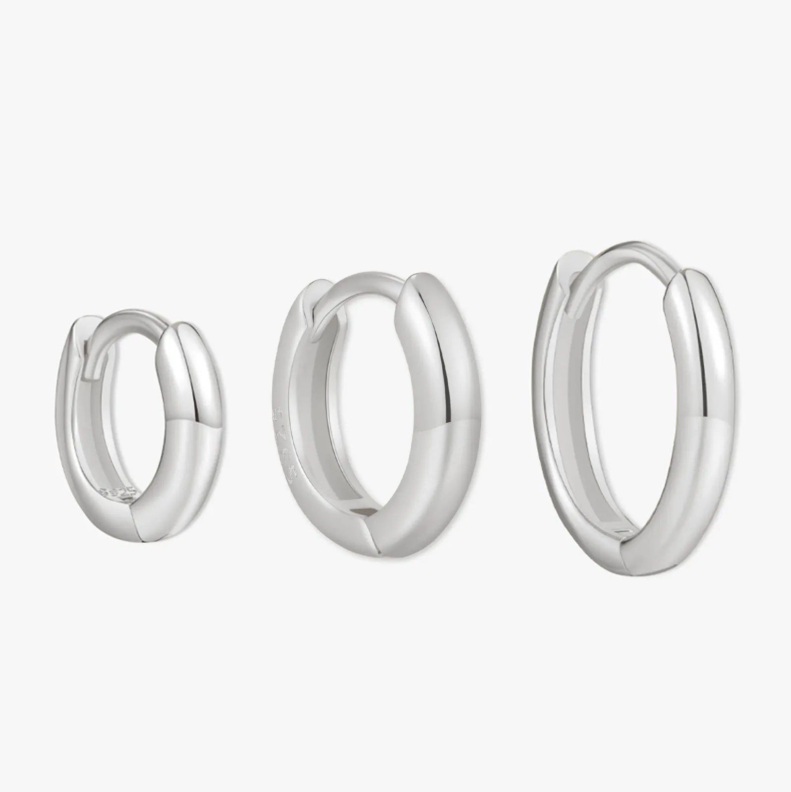 Set of three silver hoop earrings on a white background