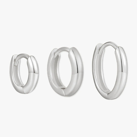 Set of three silver hoop earrings on a white background