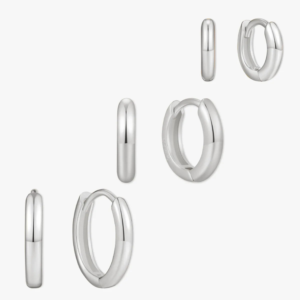 Set of silver hoop earrings on a white background