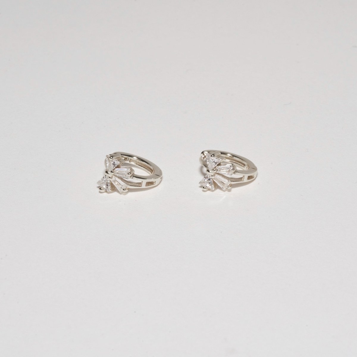 Crystal Bow Huggie Hoops In Silver - LÉA