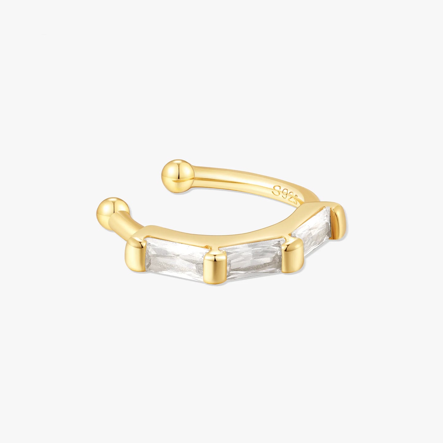 Gold ear cuff with baguette cut gemstone on a white background