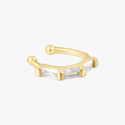 Gold ear cuff with baguette cut gemstone on a white background
