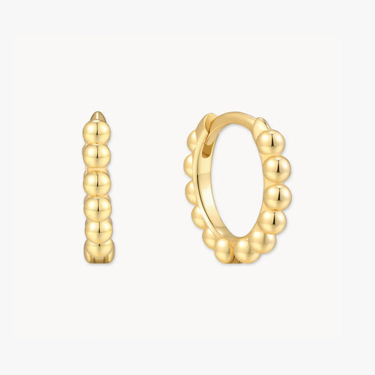 Gold hoop earrings with a beaded design on a white background