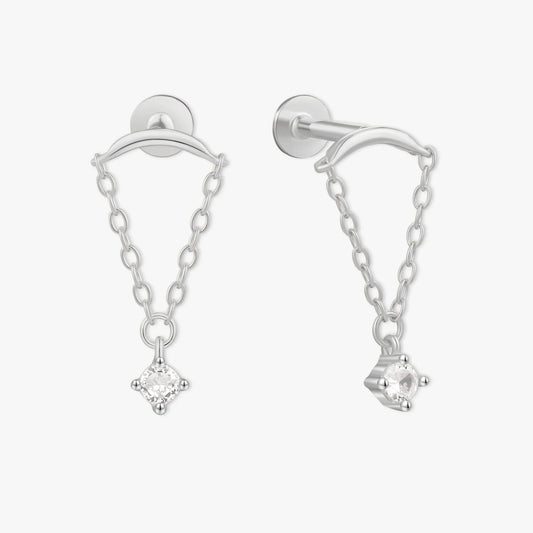 Silver earrings with chain and clear gemstones on a white background