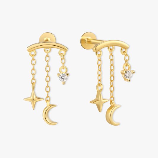 Gold earrings with star and moon designs on a white background