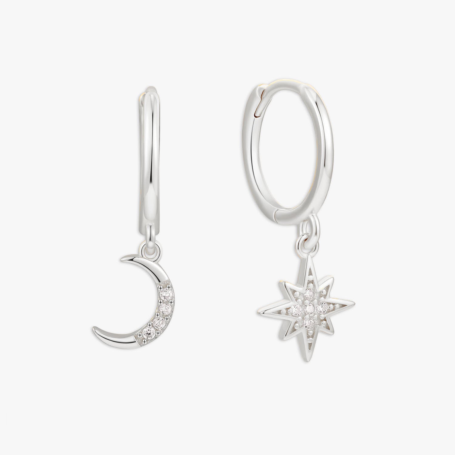 Silver hoop earrings with moon and star charms on a white background