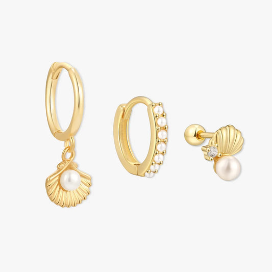 Gold hoop earrings with pearl charms on a white background