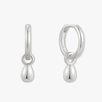 Pair of silver hoop earrings with teardrop charms on a white background