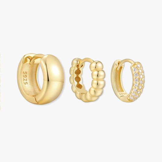 Three gold hoop earrings on a white background