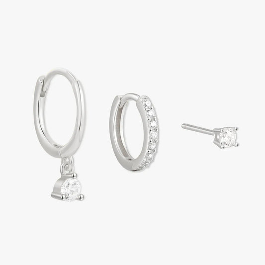 Set of silver hoop earrings and a single stud earring on a white background