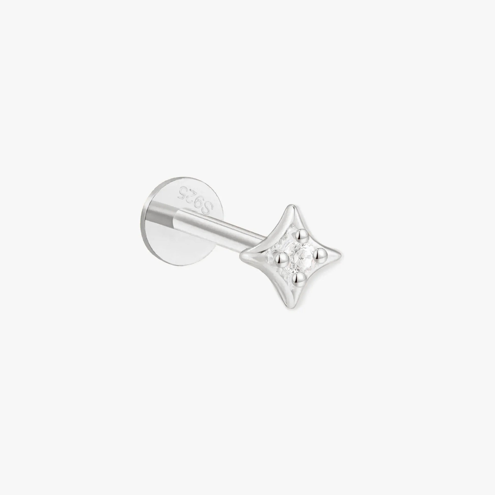 Silver star-shaped earring on a white background