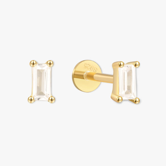 Gold earrings with clear gemstones on a white background