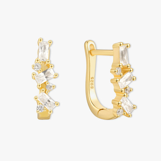 Gold hoop earrings with clear gemstones on a white background