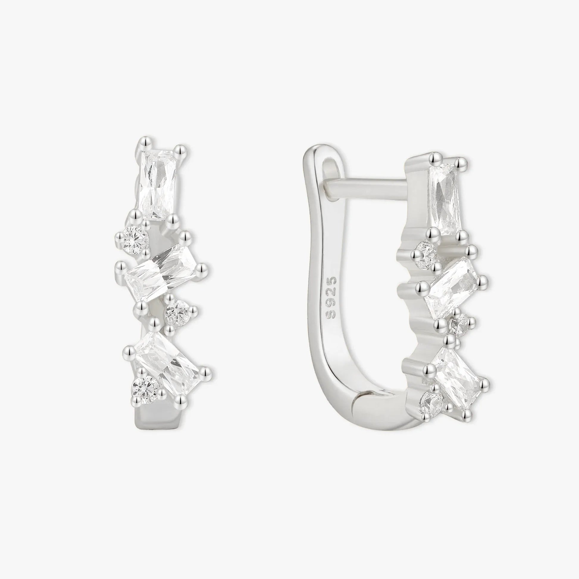 Silver hoop earrings with clear gemstones on a white background