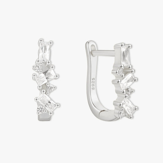Silver hoop earrings with clear gemstones on a white background