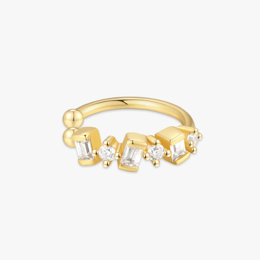 Gold ear cuff with embedded diamonds on a white background