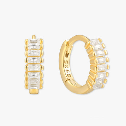 Gold hoop earrings with clear gemstones on a white background