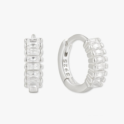 Silver hoop earrings with baguette cut stones on a white background