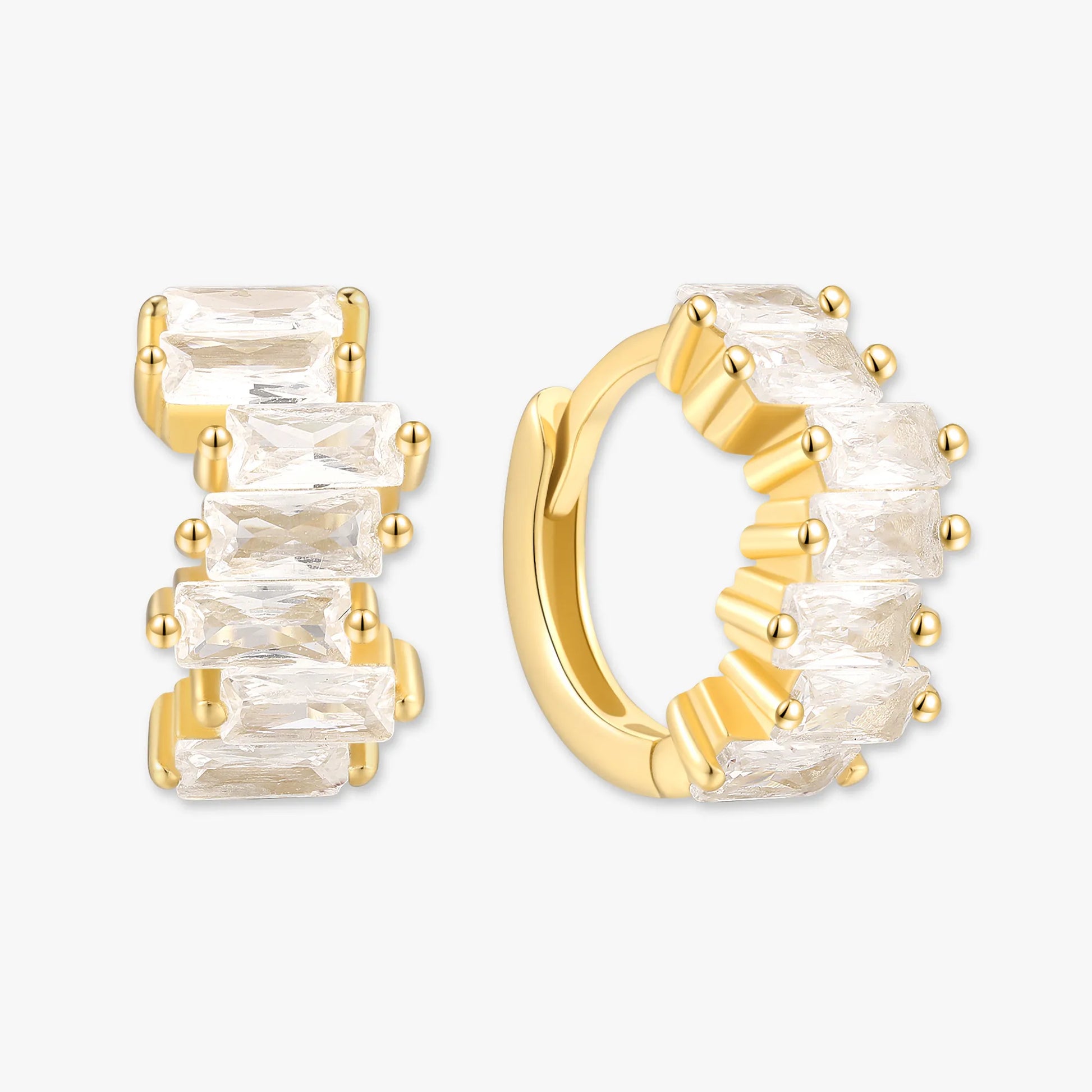 Gold hoop earrings with clear gemstones on a white background
