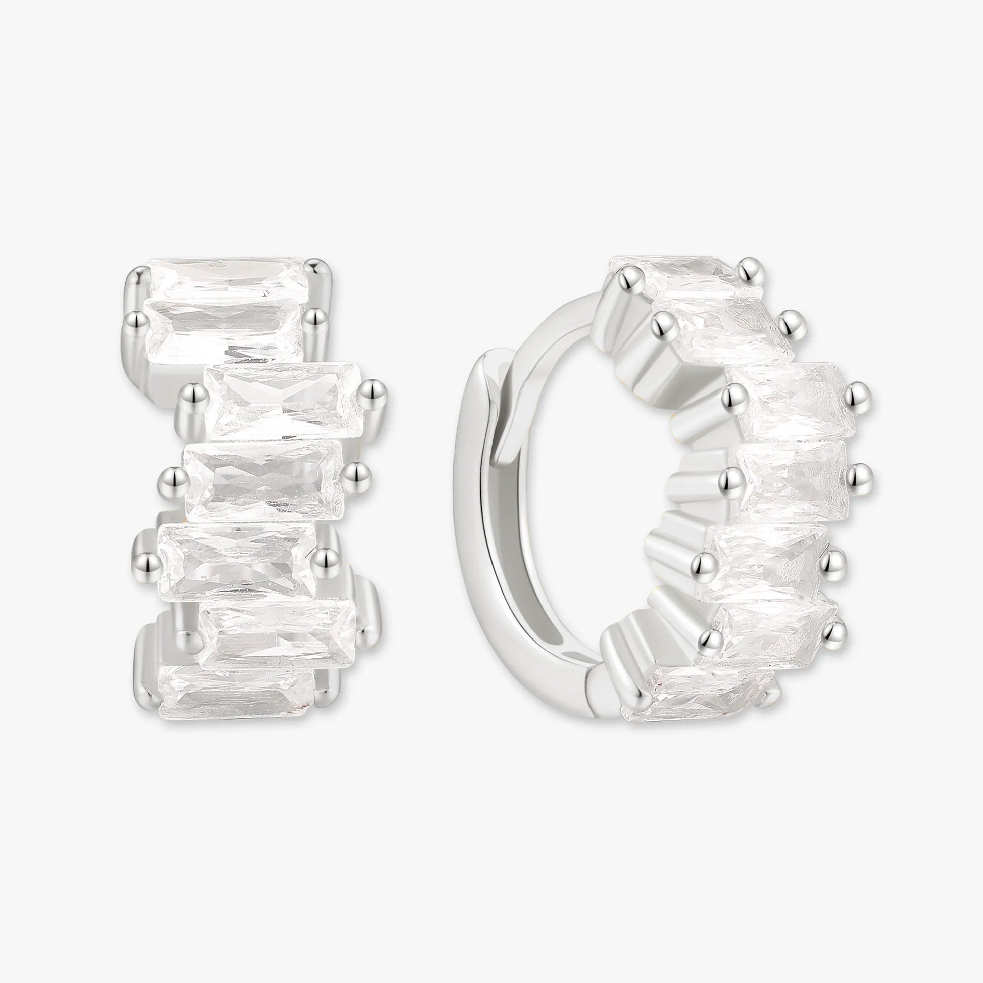 Silver hoop earrings with clear gemstones on a white background