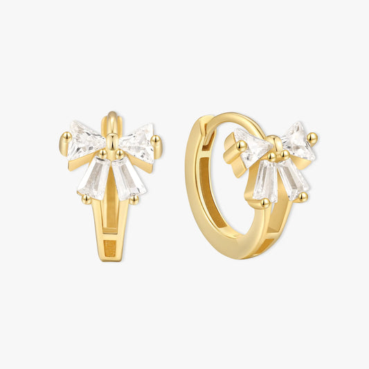 Gold hoop earrings with bow designs on a white background