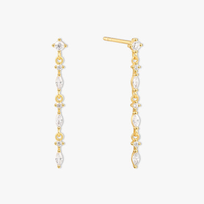 Gold and pearl drop earrings on a white background