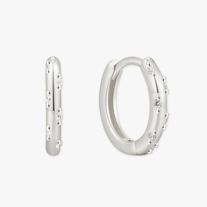 Silver hoop earrings with small diamonds on a white background