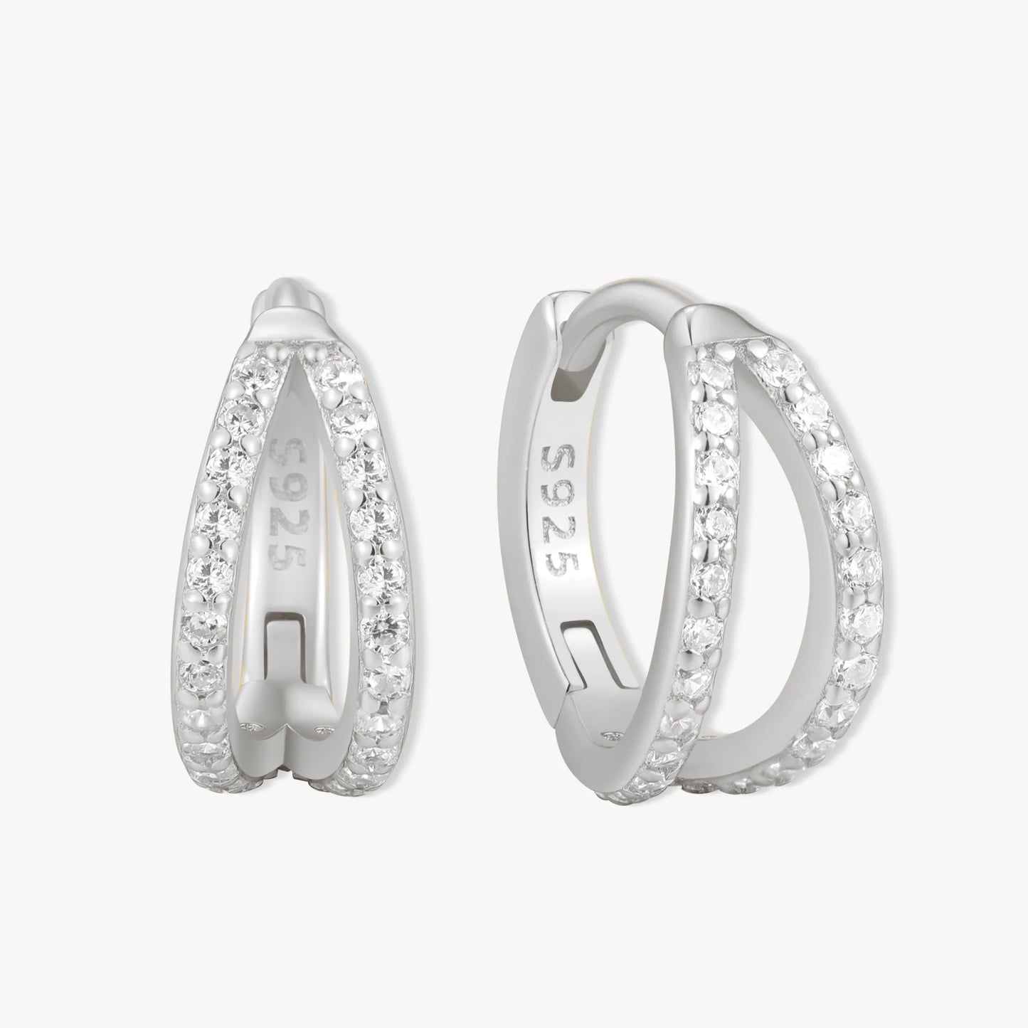 Silver hoop earrings with embedded stones on a white background