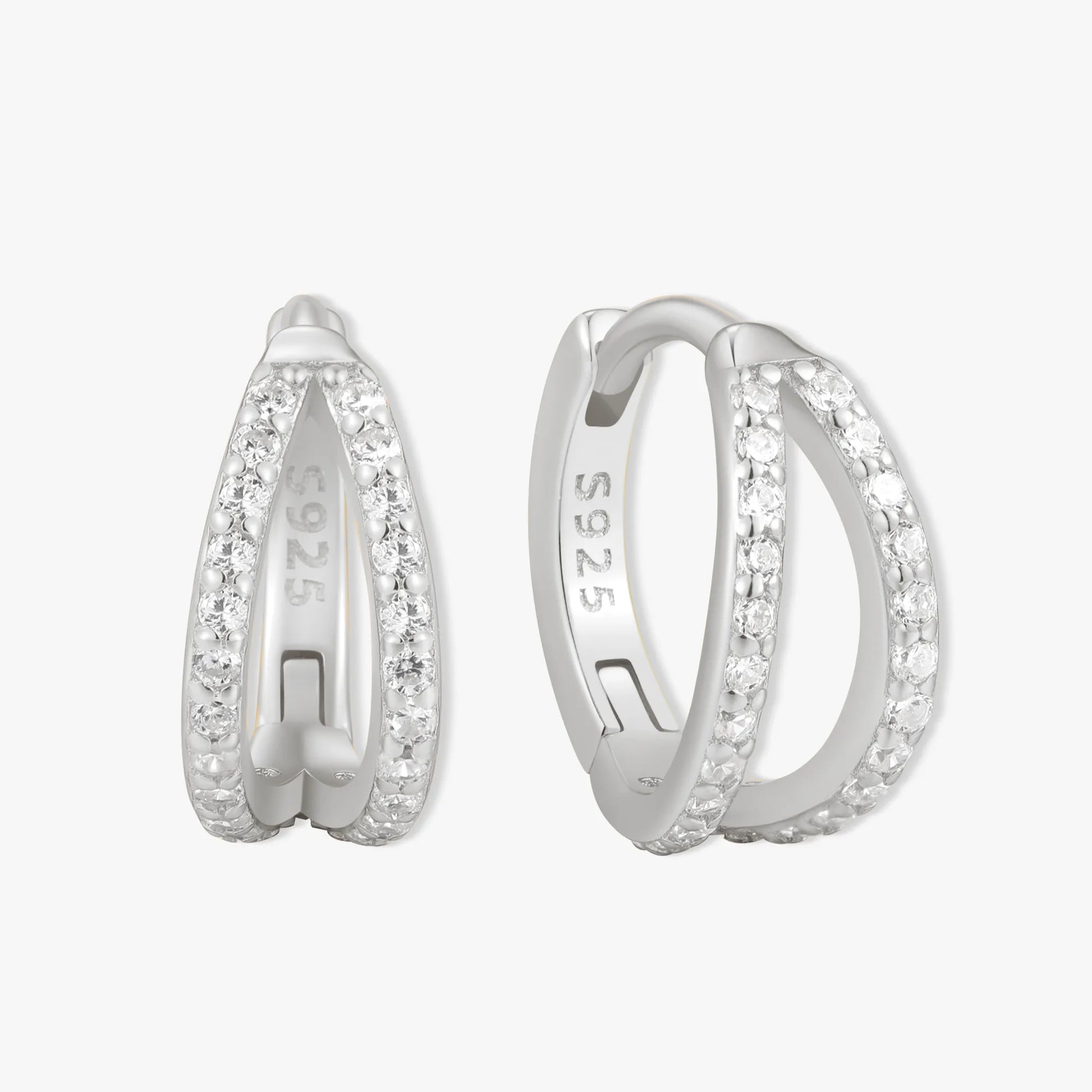 Silver hoop earrings with embedded stones on a white background