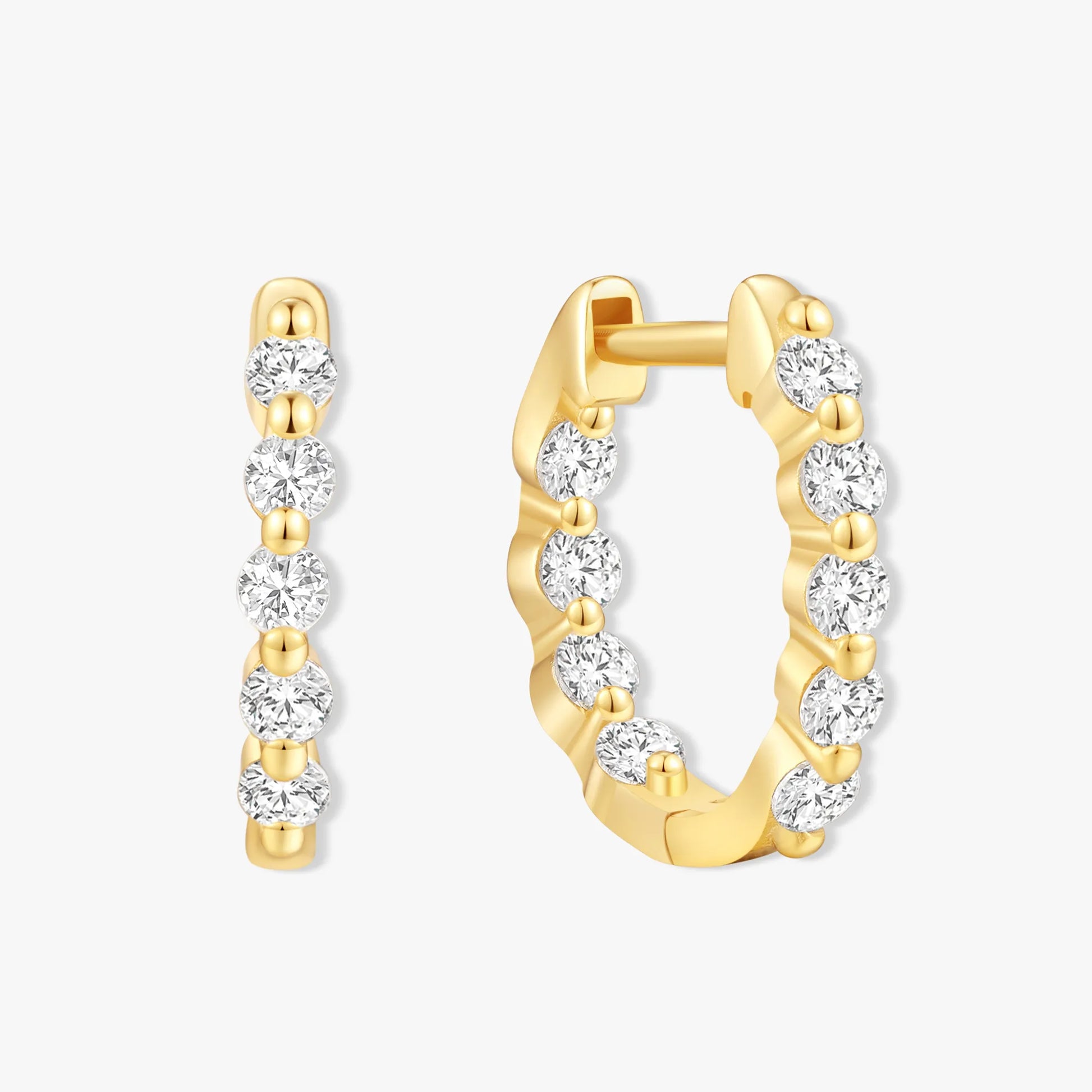 Gold hoop earrings with clear gemstones on a white background