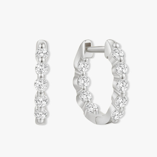Silver hoop earrings with clear gemstones on a white background