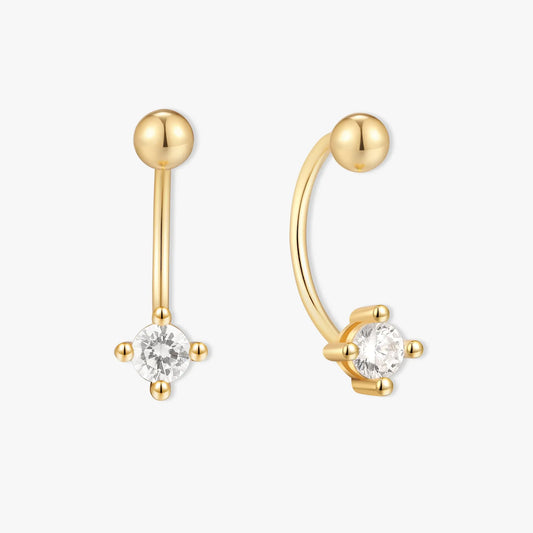 Gold earrings with clear gemstones on a white background