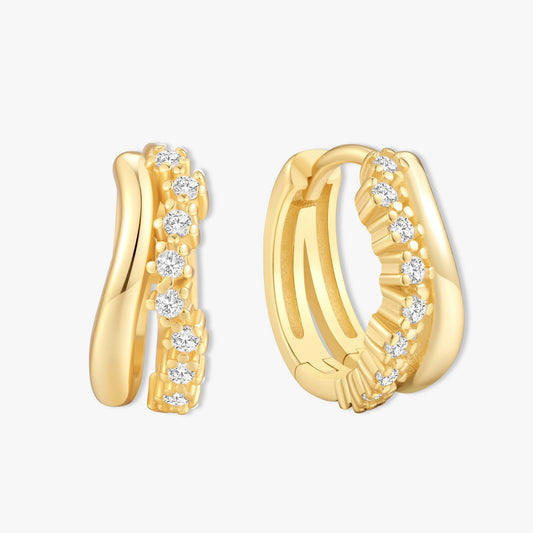 Gold hoop earrings with embedded diamonds on a light gray background