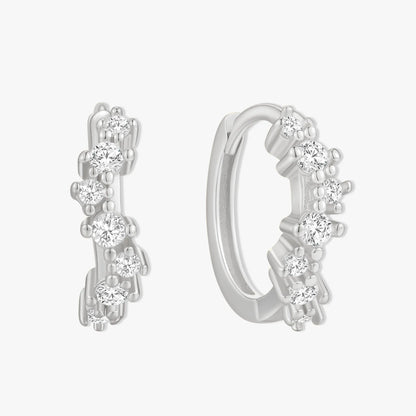 Silver hoop earrings with clear gemstones on a white background