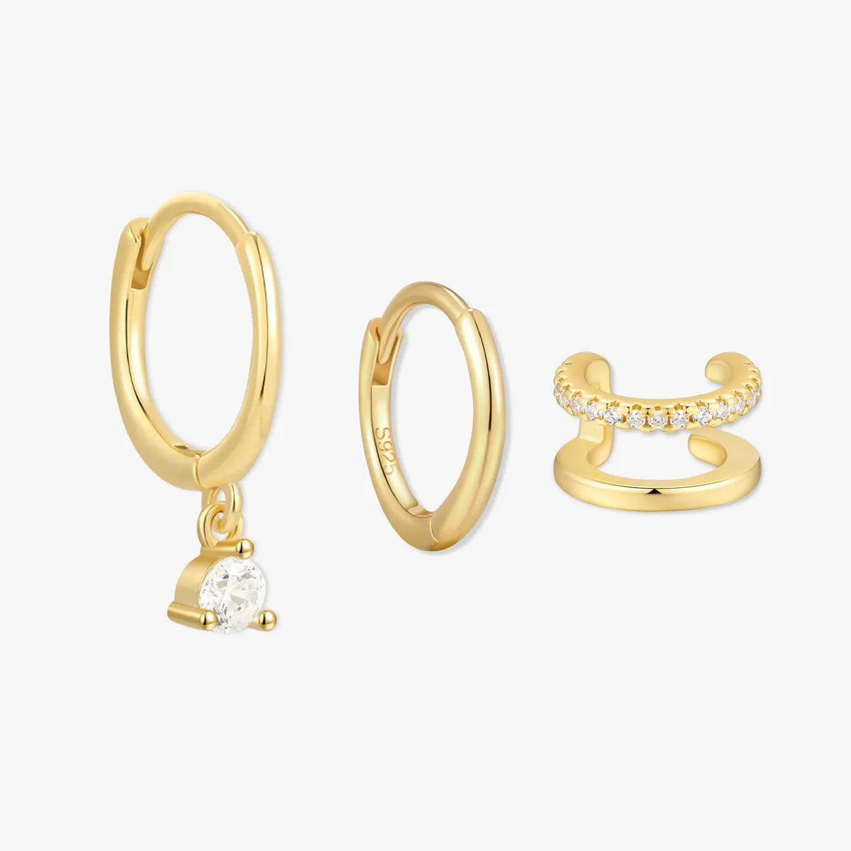Set of gold hoop earrings and a ring on a white background