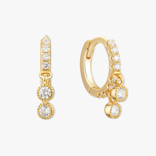 Gold hoop earrings with clear gemstones on a white background