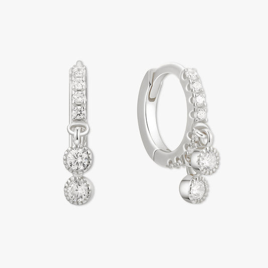 Pair of silver hoop earrings with clear gemstones on a white background