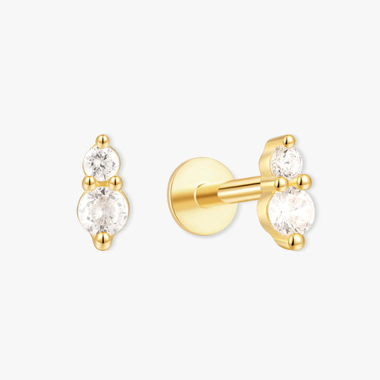 Gold earrings with clear gemstones on a white background