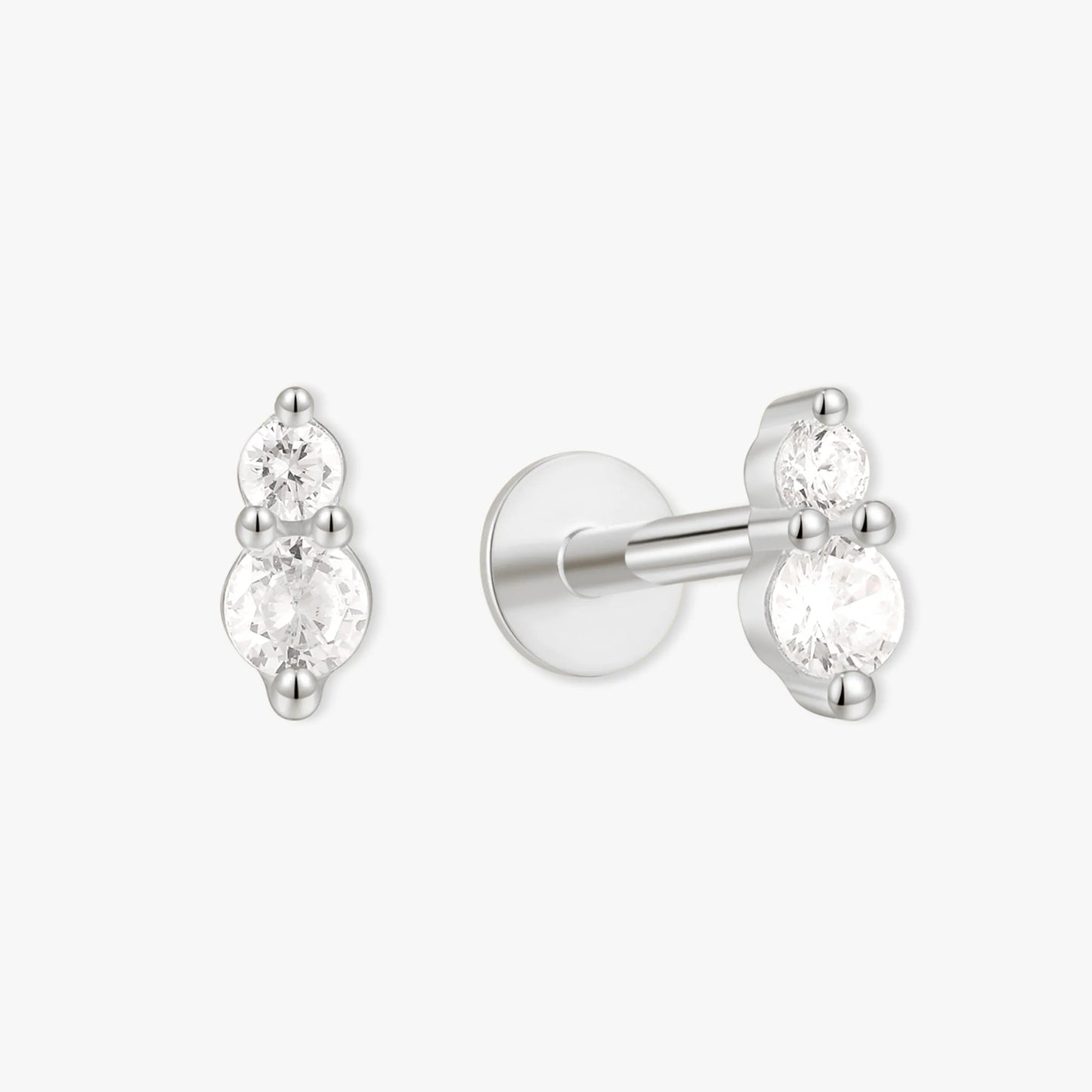 Pair of silver earrings with clear gemstones on a white background