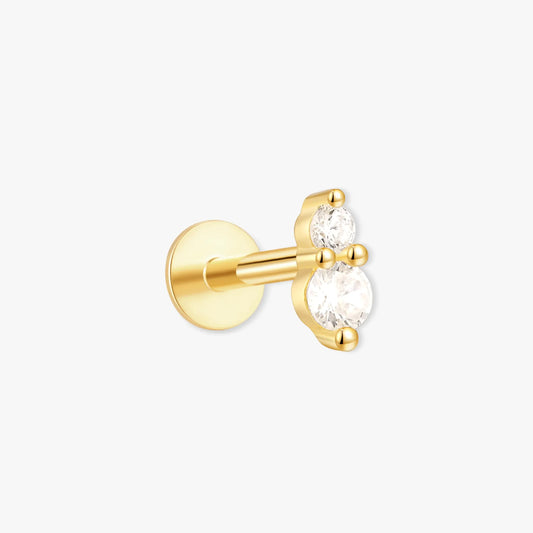 Gold earring with clear gemstone on a white background