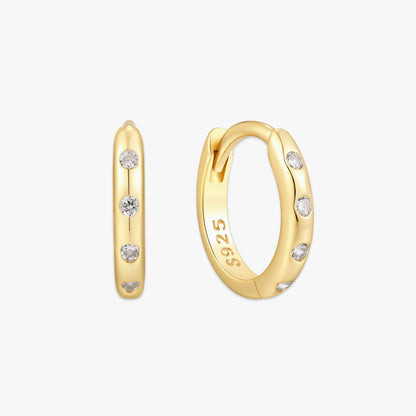 Gold hoop earrings with embedded diamonds on a white background