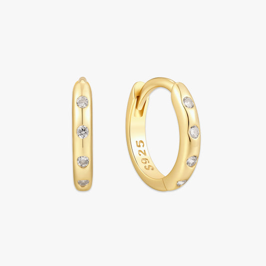 Gold hoop earrings with embedded diamonds on a white background