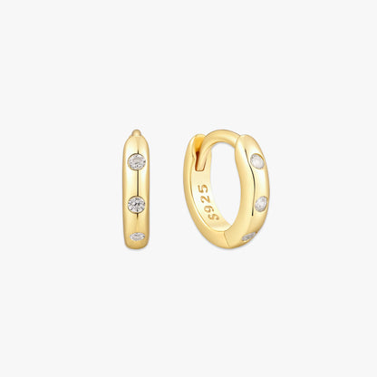 Gold hoop earrings with embedded diamonds on a white background