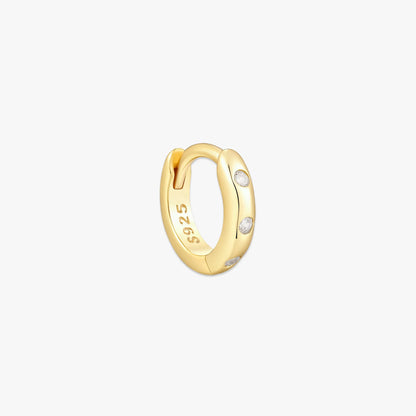 Gold hoop earring with embedded stones on a white background