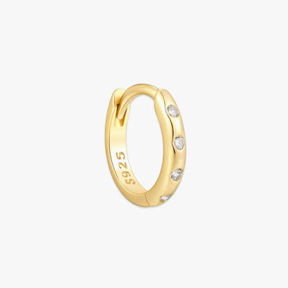 Gold hoop earring with small diamonds on a light gray background