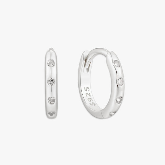 Silver hoop earrings with small diamonds on a white background